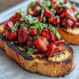 Glistening balsamic glaze dripping over fresh strawberry bruschetta on toasted bread.