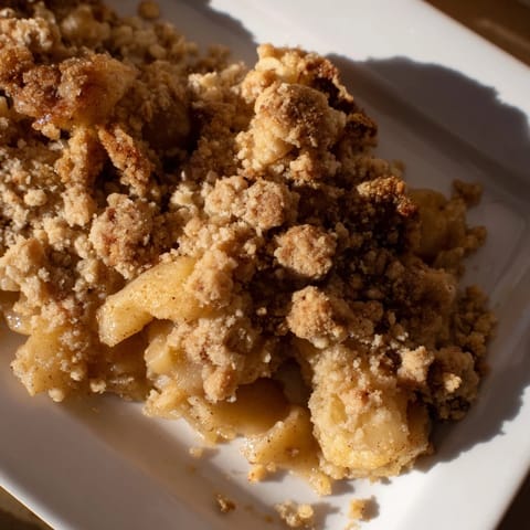 Warm, bubbling apple filling under a crisp, golden Apple Crumble topping, ready to serve.