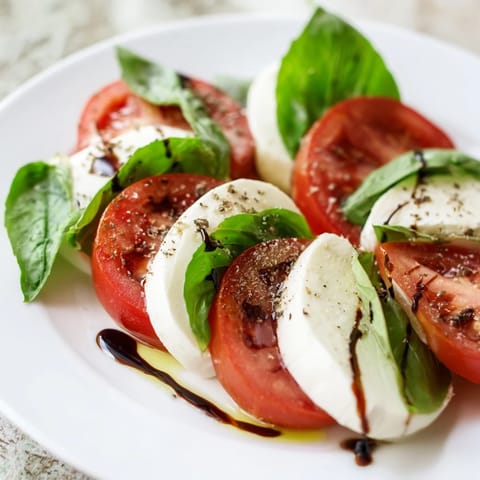 A beautiful Caprese salad, featuring fresh basil and juicy tomatoes on a serving platter.