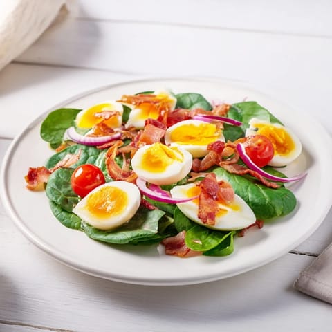 Fresh spinach salad with bacon, featuring crispy bacon, eggs, & a tangy dressing, ready to enjoy.