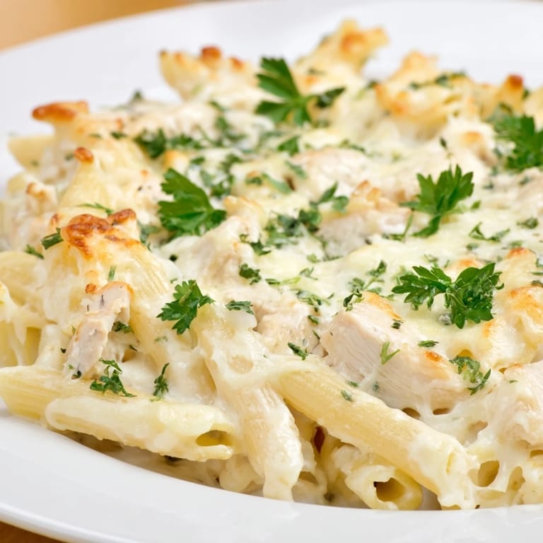 A creamy Chicken Alfredo Bake with a golden, melted cheese crust, ready to be served.