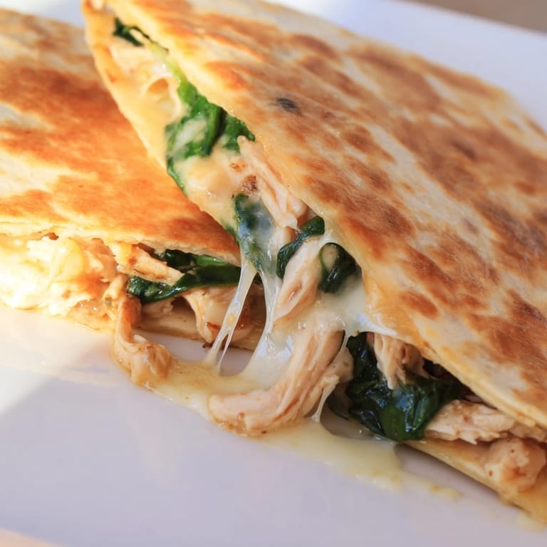 Freshly grilled Chicken and Spinach Quesadilla served with a side of salsa and sour cream for a quick, satisfying meal.