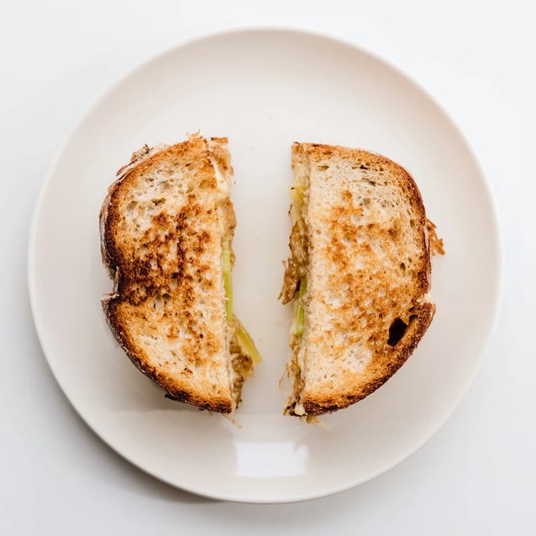 Toasted sourdough bread reveals sweet, savory Havarti & Caramelized Leek Grilled Cheese filling.