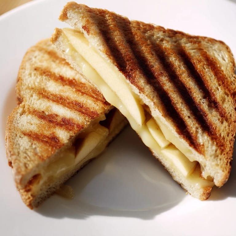 Close-up of a Smoked Gouda & Apple Grilled Cheese, highlighting the gooey, melted cheese and crisp, fresh apple layers.