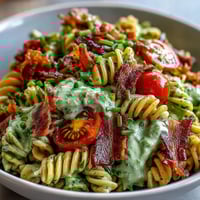 Vibrant BLT pasta salad with avocado ranch, featuring crispy bacon, fresh lettuce, and juicy cherry tomatoes in a creamy dressing.